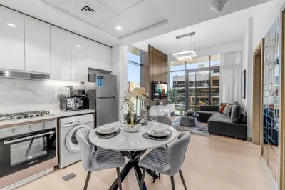 a kitchen and living room with a table and chairs at Stylish Apartment in Meydan in Dubai