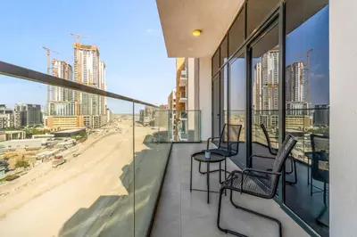 a balcony with chairs and a view of a beach at Stylish Apartment in Meydan in Dubai