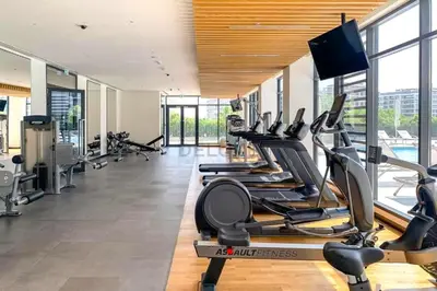 a gym with several treadmills and cardio machines at Next to Dubai Hills Park 1BR, Moments from Dubai Hills Mall, Executive Residences 2, Dubai Hills Estate by Deluxe Holiday Homes in Dubai