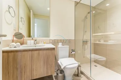 a bathroom with a shower and a toilet and a sink at Next to Dubai Hills Park 1BR, Moments from Dubai Hills Mall, Executive Residences 2, Dubai Hills Estate by Deluxe Holiday Homes in Dubai