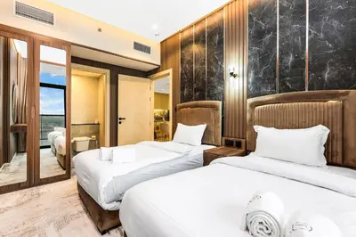 a hotel room with two beds and a window at Spacious 3BR Family Stay with Balcony Views of Burj and City Lights in Dubai