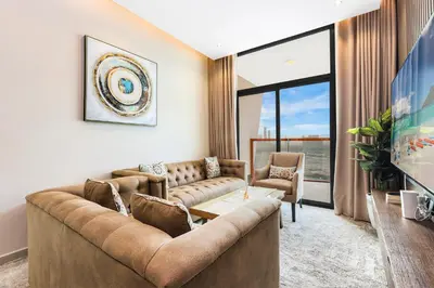 a living room with a couch and a large window at Spacious 3BR Family Stay with Balcony Views of Burj and City Lights in Dubai