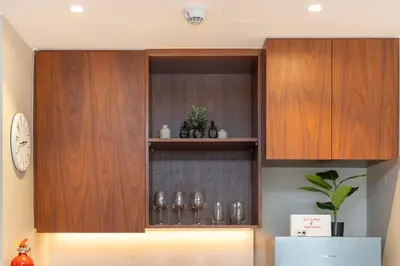 a kitchen with wooden cabinets with glasses on them at Günstige Unterkunft mit Hafenblick in Port de La Mer in Dubai