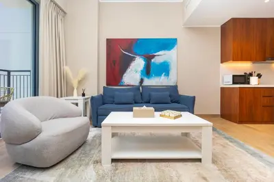a living room with a blue couch and a table at Günstige Unterkunft mit Hafenblick in Port de La Mer in Dubai