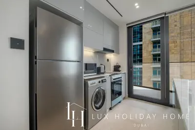 a kitchen with a refrigerator and a dishwasher at LUX The Modern Binghatti Canal Suite 3 in Dubai