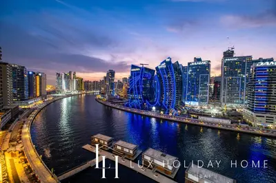 a city at night with a river and buildings at LUX The Modern Binghatti Canal Suite 3 in Dubai