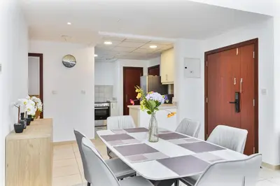a dining room and kitchen with a table and chairs at Chic 2-bed Oasis with Marina Views Walk to Beach! in Dubai