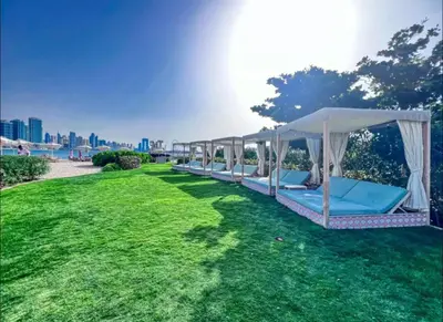 a row of lounge chairs in a field of grass at Beachfront Bliss Seven Palm in Dubai