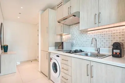a kitchen with a sink and a washing machine at Beachfront Bliss Seven Palm in Dubai