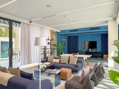 a living room with purple couches and a tv at Silkhaus Chic Studio in Sobha Hartland at Kensington in Dubai