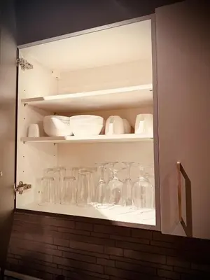 a cabinet filled with glasses and bowls and plates at Luxury Modern Apt in JBR 2 MIN to BEACH in Dubai