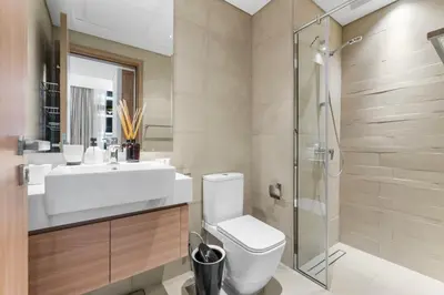 a bathroom with a toilet and a sink and a shower at Sleek Cozy Apartments in Meydan in Dubai