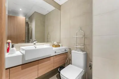 a bathroom with a sink and a toilet and a mirror at Sleek Cozy Apartments in Meydan in Dubai