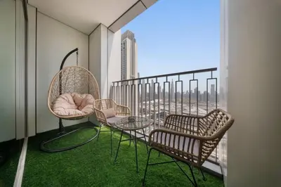 a balcony with chairs and tables and a view of the city at Serene 2BR Burj View DT Dubai in Dubai
