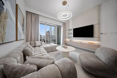 a living room with a large couch and a tv at Serene 2BR Burj View DT Dubai in Dubai