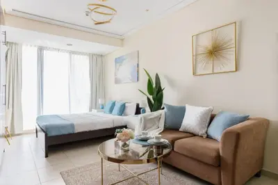 a living room with a couch and a bed at The Minimalist JLT Studio in Dubai