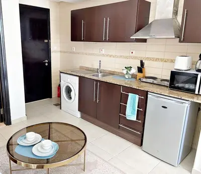 a kitchen with a table and a dishwasher at The Minimalist JLT Studio in Dubai