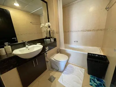 a bathroom with a sink and a toilet and a tub at The Minimalist JLT Studio in Dubai
