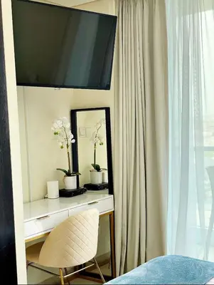 a bedroom with a desk with a mirror and a chair at The Minimalist JLT Studio in Dubai
