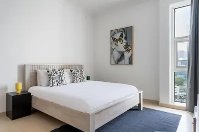 a white bedroom with a large bed and a window at GuestReady - Canal View Stay in Business Bay in Dubai