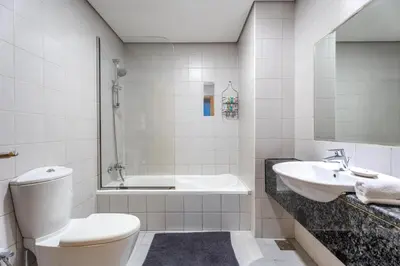 a bathroom with a toilet and a sink and a tub at GuestReady - Canal View Stay in Business Bay in Dubai
