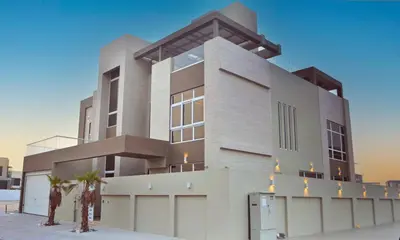 a large building with some palm trees in front of it at Luxury 5 Bedroom Villa Nad Al Sheba in Dubai