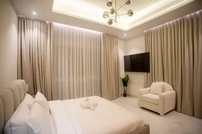 a bedroom with a white bed and a chair at Luxury 5 Bedroom Villa Nad Al Sheba in Dubai