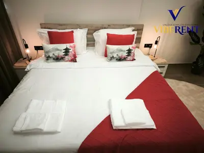 a large white bed with red and white pillows at Explore Dubai from Aura - 2BHK in Dubai