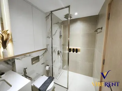 a bathroom with a shower and a toilet and a sink at Explore Dubai from Aura - 2BHK in Dubai