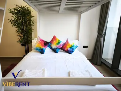 a white bed with colorful pillows in a room at Explore Dubai from Aura - 2BHK in Dubai