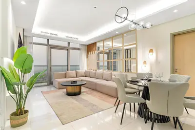a living room with a couch and a table and chairs at Luxe 3BR in Paramount with Ocean View & Infinity Pool in Dubai