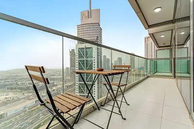 a balcony with a table and chairs on a building at Luxe 3BR in Paramount with Ocean View & Infinity Pool in Dubai
