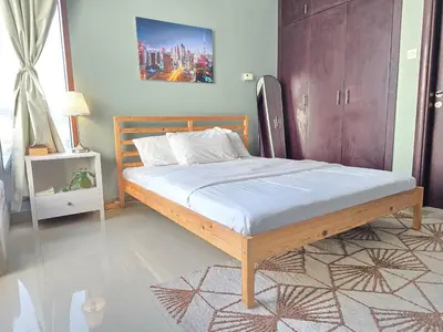 a bed with a wooden frame in a bedroom at Chic studio in Central Dubai in Dubai