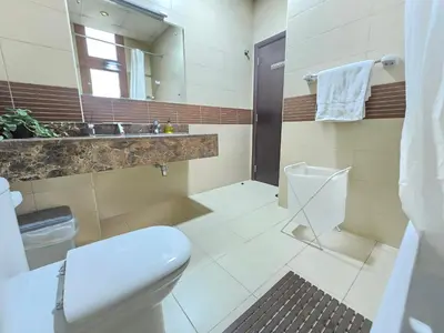 a bathroom with a toilet and a sink and a mirror at Chic studio in Central Dubai in Dubai
