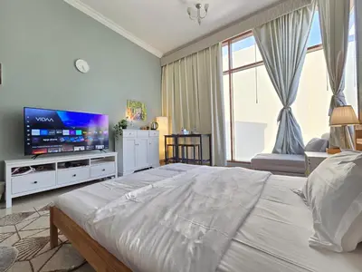 a bedroom with a large bed and a flat screen tv at Chic studio in Central Dubai in Dubai