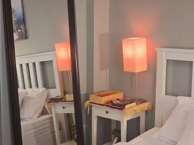 a mirror in a bedroom with a bed and a lamp at Airy and Bright Near DIFC and the Subway in Dubai