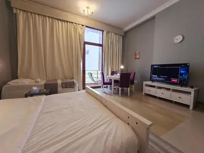 a bedroom with a bed and a tv and a table at Airy and Bright Near DIFC and the Subway in Dubai