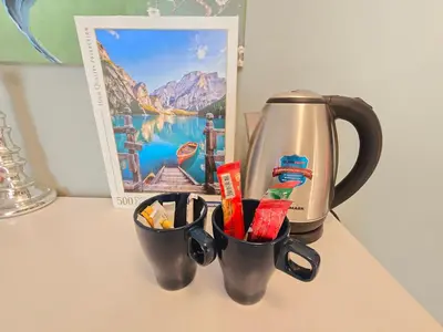 two cups with utensils on a counter next to a coffee maker at Airy and Bright Near DIFC and the Subway in Dubai