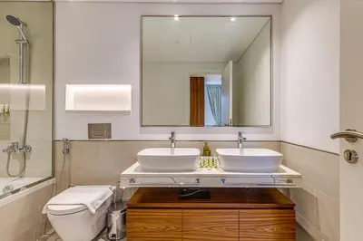 a bathroom with two sinks and a toilet and a mirror at Elegant 2 Bedroom Apartment - Jadeel 2, Madinat Jumeirah - Allsopp & Allsopp in Dubai