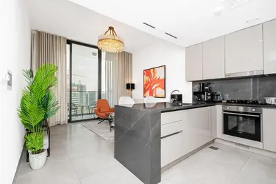 a kitchen with white cabinets and a black counter top at Escape24 Brand New 1BR with City View near Burj Khalifa in Dubai