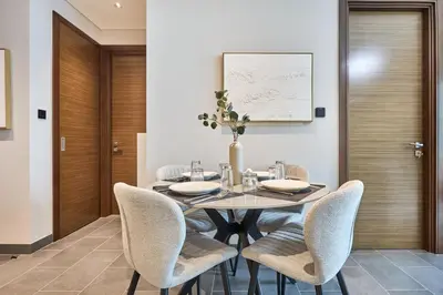 a dining room with a table and chairs at STAY BY LATINEM Luxury 1BR Holiday Home CA 1506 Near Burj Khalifa in Dubai