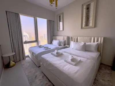 two beds in a hotel room with a large window at GRANDE RESIDENCES with a direct Burj Khalifa view and Private Fountain Show at 62nd floor with DXB AIRPORT VIP Shuttle option for 8 guests in Dubai