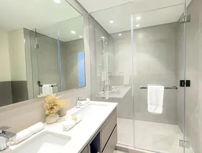 a bathroom with a sink and a glass shower at GRANDE RESIDENCES with a direct Burj Khalifa view and Private Fountain Show at 62nd floor with DXB AIRPORT VIP Shuttle option for 8 guests in Dubai
