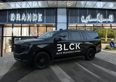 a black suv parked in front of a building at GRANDE RESIDENCES with a direct Burj Khalifa view and Private Fountain Show at 62nd floor with DXB AIRPORT VIP Shuttle option for 8 guests in Dubai