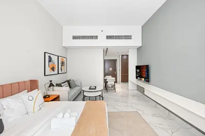 a living room with a bed and a couch at Unwind in a Stylish Studio with Pool, Sauna, and Stunning City Views in Dubai