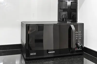 a microwave oven sitting on top of a counter at Unwind in a Stylish Studio with Pool, Sauna, and Stunning City Views in Dubai