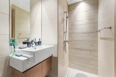 a bathroom with a white sink and a shower at Cozy Luxe Studios in Meydan in Dubai