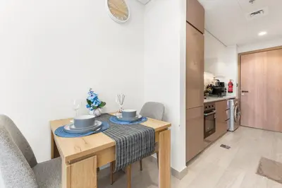 a kitchen and dining room with a table and chairs at Cozy Luxe Studios in Meydan in Dubai
