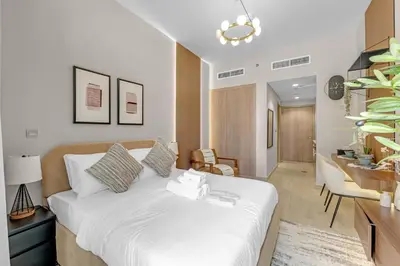 a bedroom with a bed and a living room at Cozy Luxe Studios in Meydan in Dubai