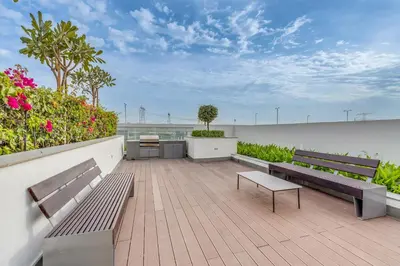 a patio with two benches and plants and flowers at 1BR Royal Bedroom with Pool & Gym Free in Dubai
